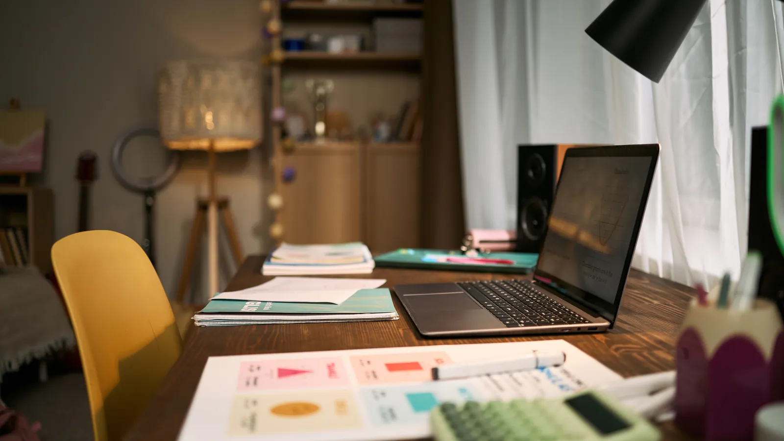 Bureau met laptop, papieren en rekenmachine.